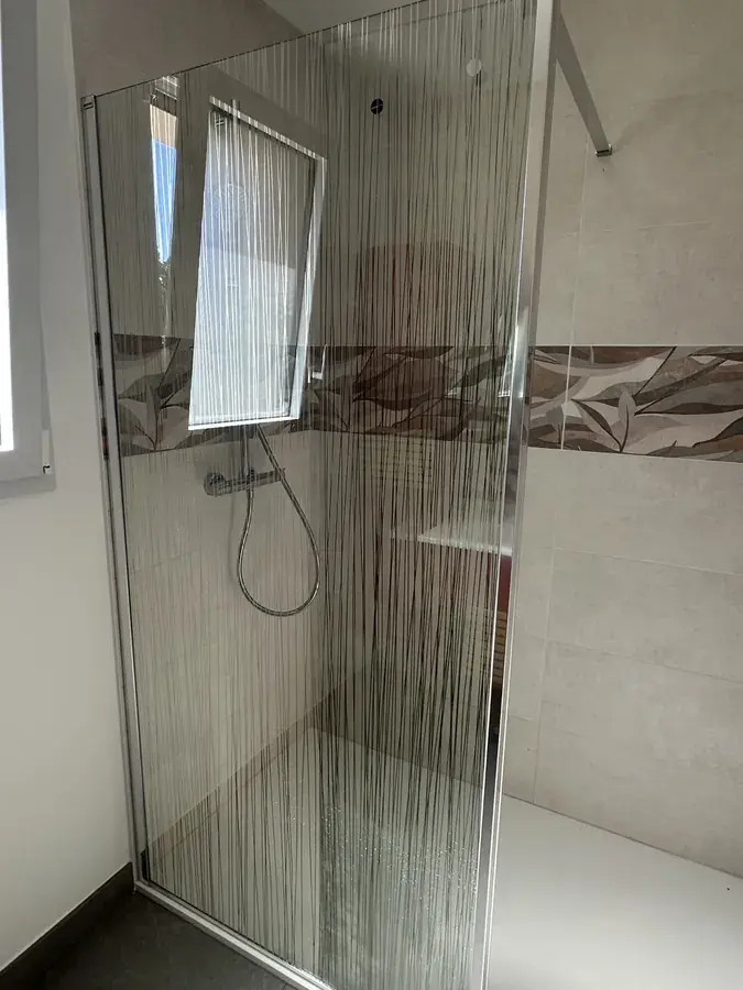 Douche à l'italienne avec paroi de verre sérigraphiée et faïence décorative