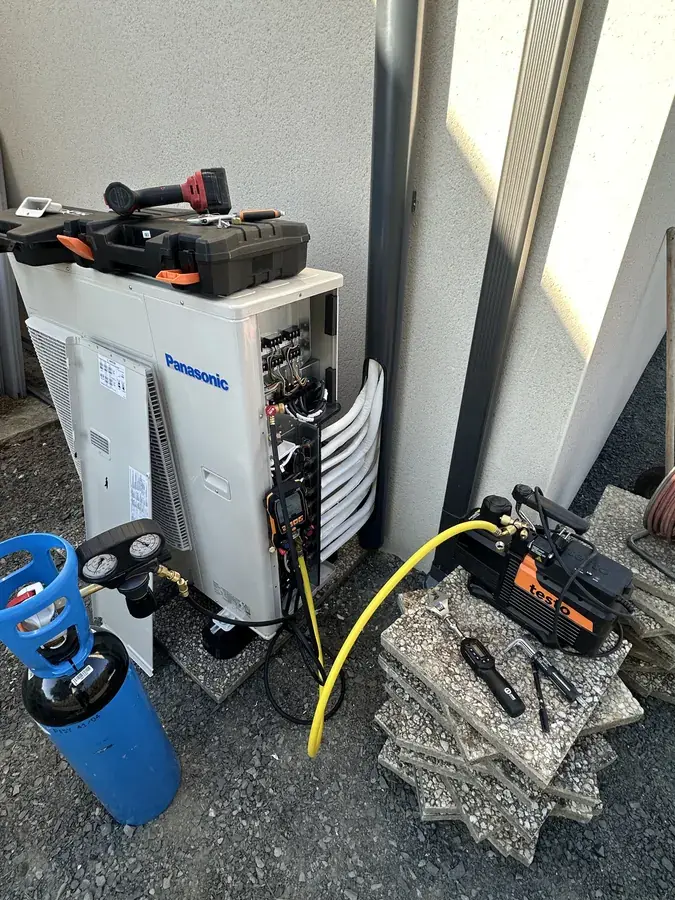 Mise en service d'une climatisation : pompe à vide et manomètres raccordés à l'unité extérieure