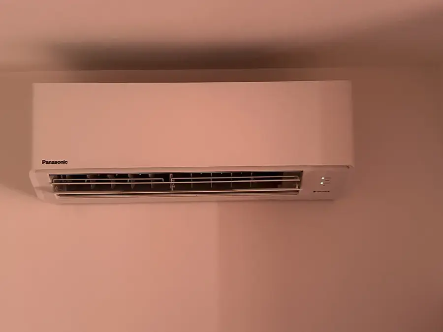 Unité intérieure murale Panasonic installée dans une chambre aux murs rose poudré