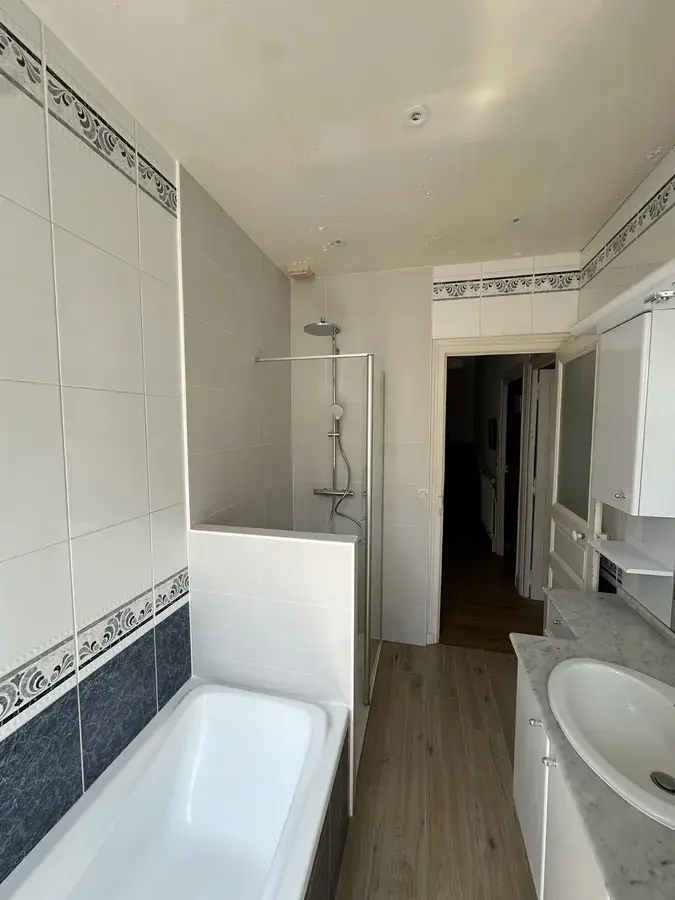 Salle de bain rénovée au Mans : baignoire conservée, douche créée au fond de la pièce