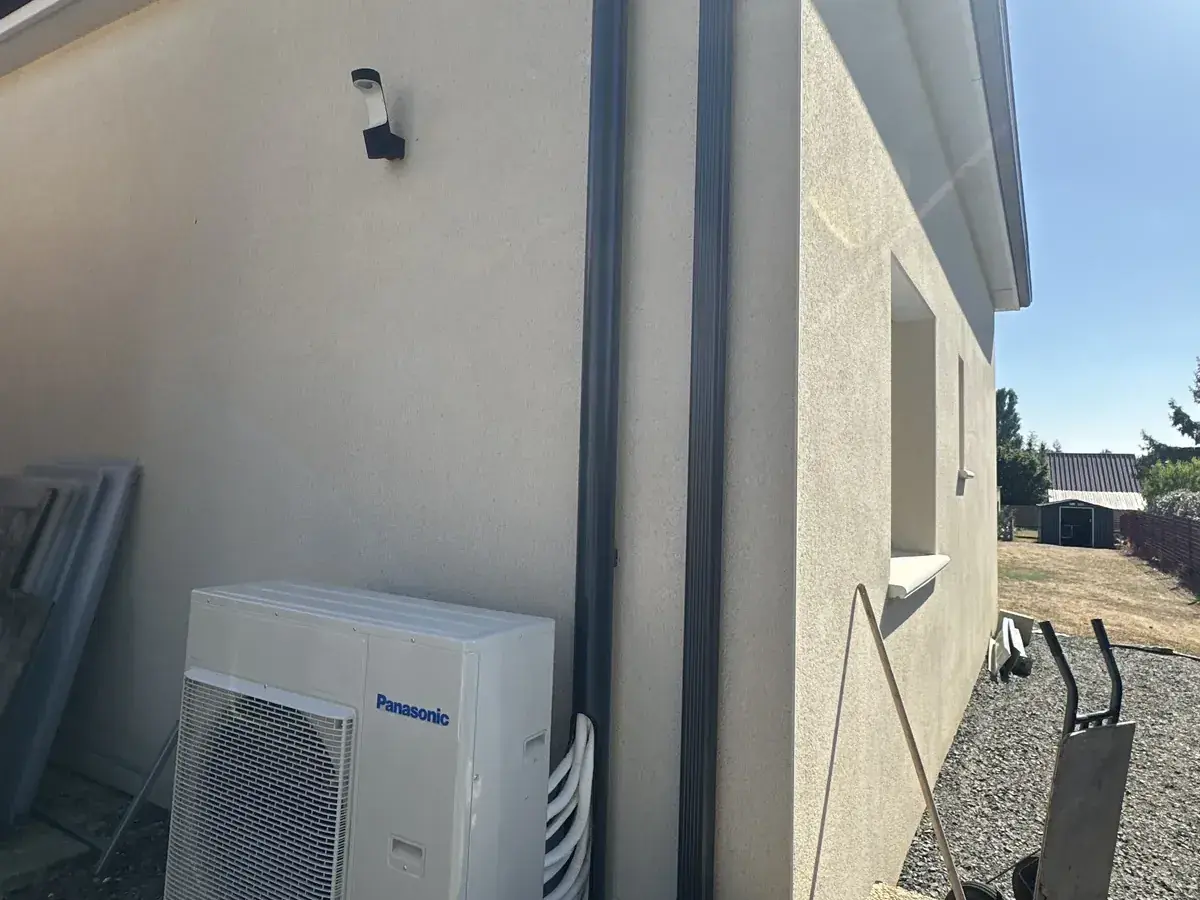 Unité extérieure de pompe à chaleur installée contre un pavillon en Sarthe