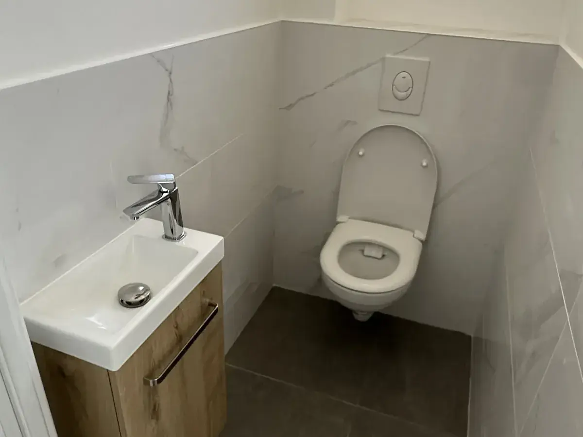 WC suspendu avec bâti-support et lave-mains installés dans une maison en Sarthe
